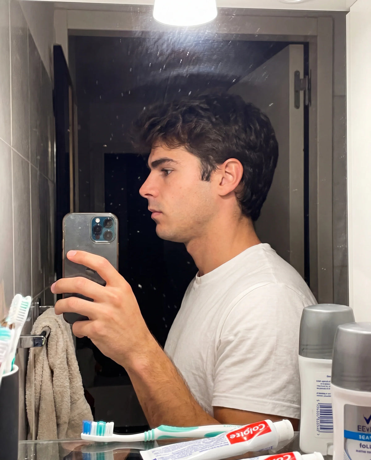 Bathroom mirror side profile shot, dark moody lighting
